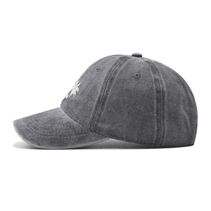 Detail of embroidered coconut palm tree on washed dark grey cotton baseball cap