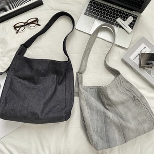 Flat lay of wide strap canvas tote bags in charcoal and light grey with daily essentials