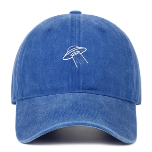 Close-up of white UFO embroidery on blue washed cotton vintage baseball cap