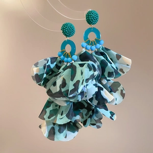 Detail view of Bohemian floral drop earrings with leopard print fabric petals and green beads