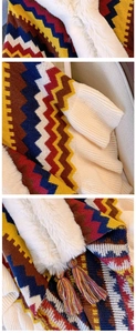 Detail of colorful knitted shawl featuring zigzag patterns, fur trim, and tassels