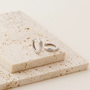 Detail view of silver S925 earrings with small diamonds showing authentic S925 hallmark