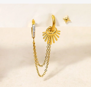 Macro detail of 18K gold tassel earring set with sun pendant and double chain