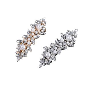 Elegant gold and silver hair clips with sparkling rhinestones and pearls on white base