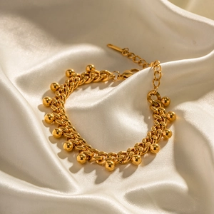 Bracelet gourmette 18K en acier doré avec breloques de perles sur fond en soie