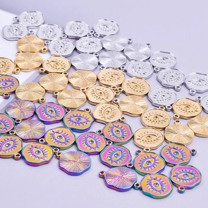 Polished steel, gold, and rainbow evil eye pendants for jewelry making on purple backdrop