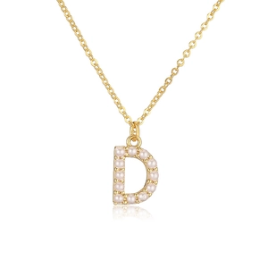 Detailed view of golden necklace pendant letter D inlaid with white pearls on white background