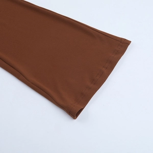 Detailed view of the brown knitted fabric and neat stitching on the jumpsuit leg hem
