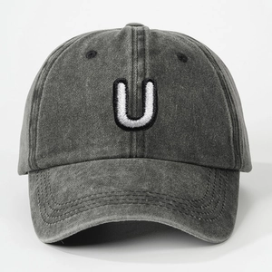 Close-up of embroidered white letter U on washed dark grey cotton baseball cap