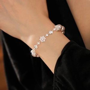 Détail du bracelet de perles élégant avec flocons en zircon sur le poignet