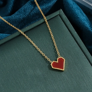 Elegant gold chain necklace featuring a red heart pendant with beaded gold edge detailing
