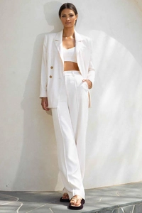 Detail of white double-breasted blazer with matching high-waist wide-leg trousers