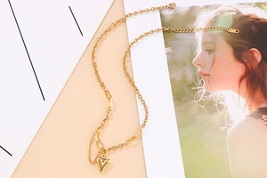 Detail of adjustable gold titanium steel heart pendant necklace with elegant chain