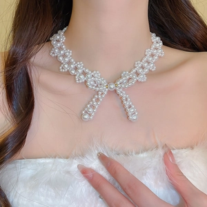 Elegant white pearl bow necklace shown on a model neck with a vintage French style
