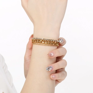 Three-layer stacked bracelet featuring a cuban chain, zircon link, and gold bead strands
