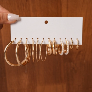 Detailed view of 9-pair gold hoop earrings set with faux pearls on display card