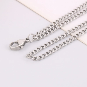 Macro detail of silver stainless steel Cuban chain link necklace with lobster clasp