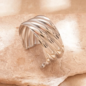 Macro detail of silver wavy cuff bracelet showing polished ripples and fluid texture