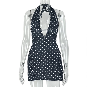 Detailed close-up of a black polka dot halter neck dress with deep V-neckline cut