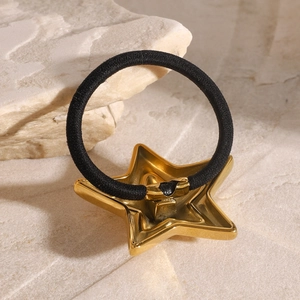Haargummi mit goldenem Stern-Anhänger und elastischem Band auf Steinsockel