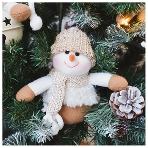 Detailed plush snowman Christmas ornament hanging on a tree with festive pine cones