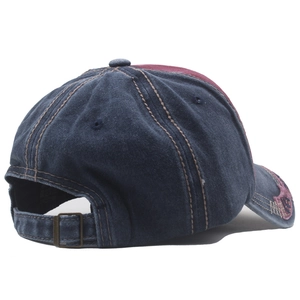Close-up of vintage washed denim cap showing bronze metal buckle and contrast stitching