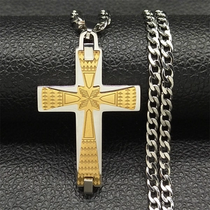 Detailed close-up of two-tone gold and silver cross pendant with textured Cuban link chain