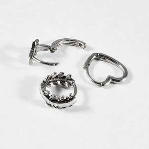 Set of three vintage silver earrings featuring heart, leaf patterns and geometric bars