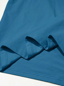 Detailed macro view of the double-stitched hem on a navy blue knit henley shirt