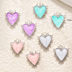 Detailed view of 19mm heart pendants in purple, turquoise, pink, and white enamel