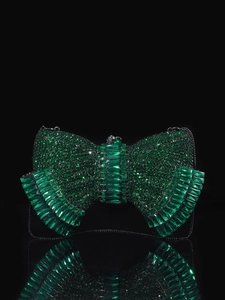 Detail of luxury emerald crystal bow clutch bag with sparkling rhinestones and chain