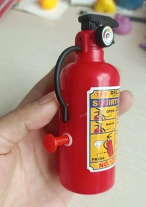 Detail of red mini fire extinguisher squirt gun toy with black handle and nozzle