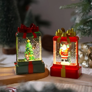 Detail of Christmas lantern gift boxes with Santa Claus and tree motifs and warm LED glow