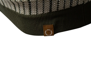 Macro detail of men's knit polo hem showing striped texture and branded side label