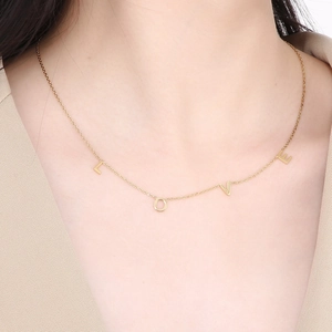 Élégant collier doré avec lettres LOVE pour femme, bijou minimaliste porté par un mannequin