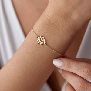 Elegant gold lotus pendant bracelet with minimalist hollow geometry on a female wrist