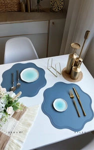 Blue leather flower-shaped placemat with petal edges and embossed texture detail