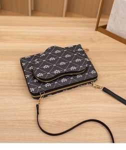 Detailansicht der Umhängetasche mit Monogramm-Muster, goldenen Details und kleiner Tasche