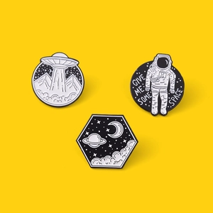 Detailed view of astronaut enamel pins with Give Me Some Space text on yellow background