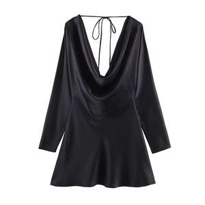 Detail of black satin dress featuring a draped cowl neck and cross-back lace-up ties