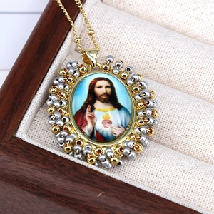 Close-up of Sacred Heart of Jesus religious pendant with colorful beads and gold chain