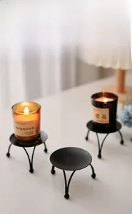 Detail of matte black iron candle holder with three-leg support for home decor