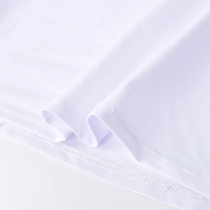 Détail en gros plan montrant les coutures précises sur l'épaule de la robe blanche