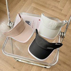 Detailed view of quick-dry sun visors with Fortravel embroidery on a lifestyle chair