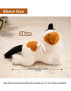 Detail shot of a 28cm calico plush cat with a white ribbon bow on a soft beige carpet