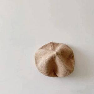 Close-up of soft khaki knit beret cap showing fine wool texture and classic painter style
