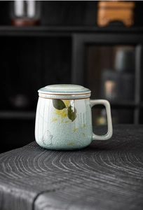 Macro detail of hand-painted ceramic tea mug with ice-crack glaze and floral motifs