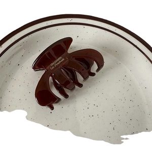 Glossy dark brown oval pumpkin hair claw clip for French style updos with white text detail