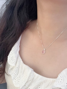 Nahaufnahme der rosa Chalcedon-Anhänger an silberner Schlangenkette an einem Model