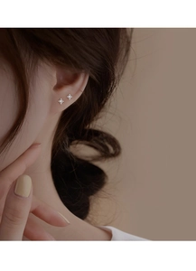 Close-up of small S925 sterling silver four-point star stud earrings with zircon